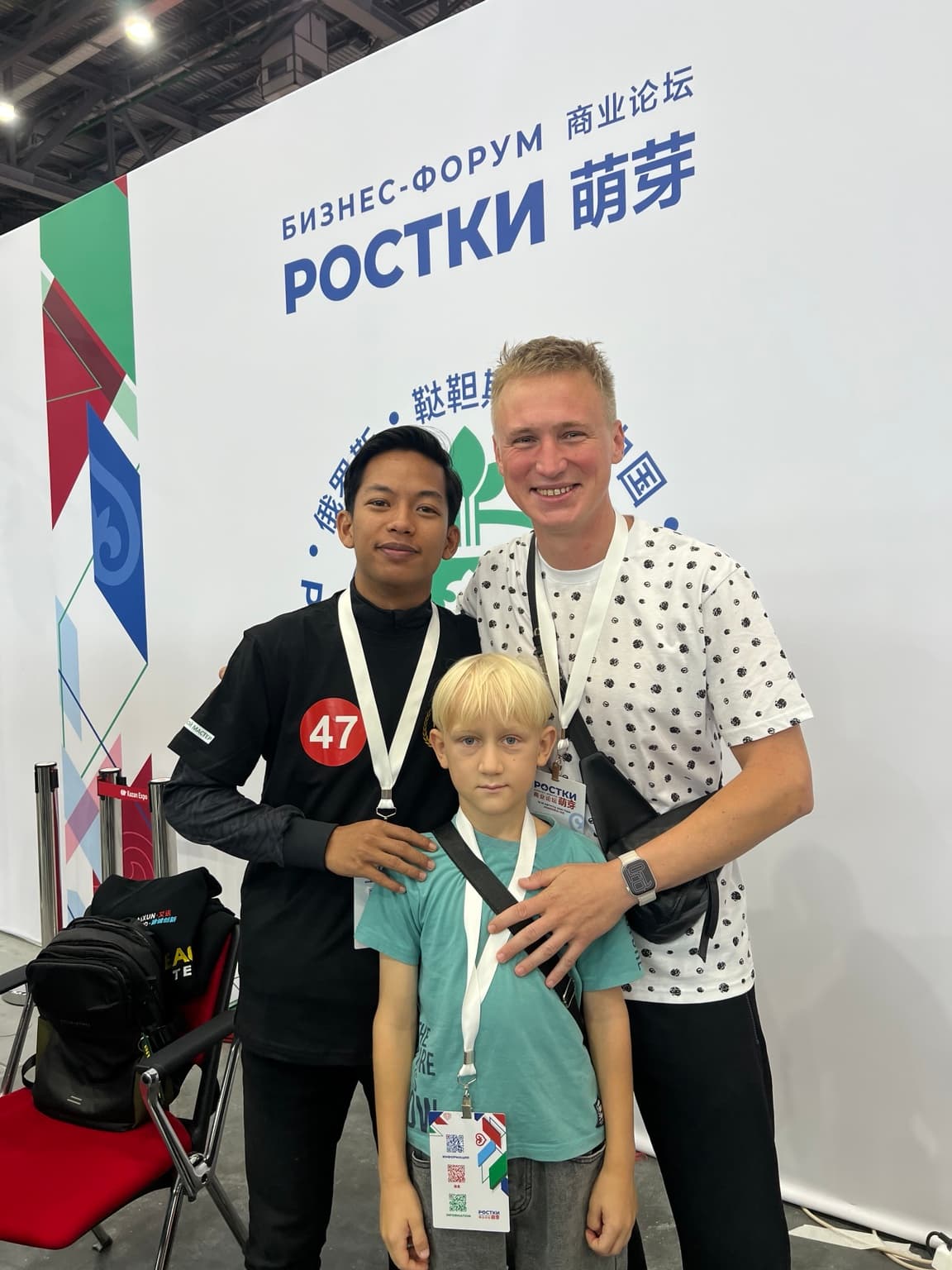 Юрий и Владислав с участником чемпионата на фоне форума «Ростки».